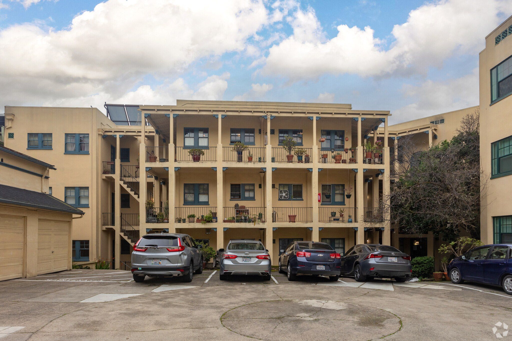 an apartment building with cars parked in a parking lot